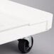 A white fiberglass MFG Tray dough proofing box dolly with black wheels.