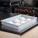 A gray MFG Tray fiberglass dough proofing box filled with dough on a counter.