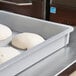 A MFG Tray fiberglass dough proofing box on a counter with dough inside.