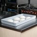 A MFG Tray gray fiberglass dough proofing box on a counter with dough in it.