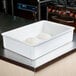 A white MFG Tray fiberglass dough proofing box with two balls of dough inside.