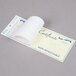 A white paper gift certificate with blue writing in a white envelope.