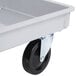 A gray fiberglass dough box dolly with black wheels.