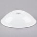 A Libbey Infinity white porcelain bowl on a gray surface.