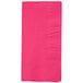 A close-up of a hot magenta pink Creative Converting paper dinner napkin.