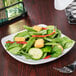 A Libbey bright white square porcelain coupe plate with a salad and a fork.