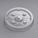 A translucent plastic lid on a table with a round slot in the center.
