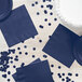 A navy blue 1/4 fold luncheon napkin on a table with navy blue plates.