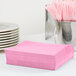 A stack of Candy Pink luncheon napkins on a table.