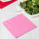 A plate of salad with a pink Creative Converting luncheon napkin on top.