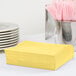 A stack of yellow Creative Converting luncheon napkins.