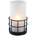 A white Sterno Gridiron lamp with a white candle inside on a black metal frame.