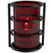 A Sterno red glass candle holder with a flame in it.