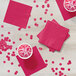 Hot magenta pink Creative Converting beverage napkins on a table with pink drinks and cups.