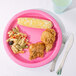 A Creative Converting candy pink paper plate with a plate of food and a glass of water.