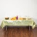 A table with a Creative Converting gold metallic plastic table cover with food on it.