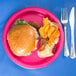 A Creative Converting hot magenta paper plate with a burger and potato chips on it.