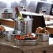 An American Metalcraft stainless steel bucket on a table with a bottle of wine and ice.