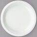 A white Creative Converting paper plate on a gray surface.