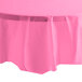 A candy pink Creative Converting OctyRound plastic table cover on a round table.