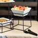 A black stand with Libbey Ultra Bright White Square Porcelain bowls of fruit on a table.