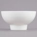 An American Metalcraft white porcelain footed bowl on a gray background.