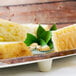An oval melamine serving board with food and leaves on it.