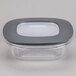 A Rubbermaid clear plastic square storage container with a black lid.