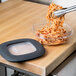 A black square Rubbermaid food storage container with a clear plastic lid holding spaghetti.