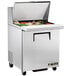 A large silver True commercial refrigerator with food inside.