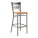 A Lancaster Table & Seating metal cross back bar stool with a cherry wood seat.