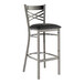A Lancaster Table & Seating clear coat finish cross back bar stool with a black vinyl padded seat.