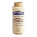 A white Ghirardelli bottle with a white and blue label reading "White Chocolate Flavoring Sauce" on a counter.
