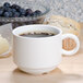 An Arcoroc stack cup of coffee next to a muffin on a white saucer.