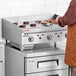 A man using a Vulcan countertop griddle to cook food in a professional kitchen.