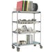 A MetroMax i mobile rack with metal shelves holding dishes and pots.