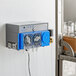 A Viking Pro V Three Warewashing Chemical Pump machine on a shelf with a glass jar.