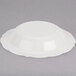 A white Fineline disposable plastic bowl with a gold rim.
