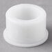 A white plastic Noble Products upper shaft bearing with a hole on a gray surface.