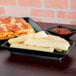 A rectangular deli server filled with food on a table.