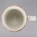 A white cup with a brown rim.