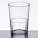 A clear Cambro plastic tumbler with a clear liquid inside.