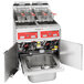 A Vulcan gas fryer system with two open fryer units and baskets over a sink.