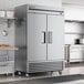 A stainless steel True reach-in freezer with solid doors.