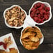 A 10 Strawberry Street white porcelain bowl caddy with 3 bowls of mixed nuts and dried fruit.