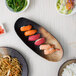 A 10 Strawberry Street Whittier Nagoya stoneware platter with sushi, noodles, and vegetables.