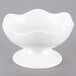 A 10 Strawberry Street Whittier white porcelain bowl with wavy sides and a small stand.