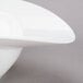 A 10 Strawberry Street Somba white porcelain oval rim bowl with a curved edge.