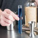 A person holding a Choice Crystal Clear test tube filled with blue liquid.