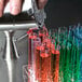 A person pouring liquid into Choice test tubes on a counter.